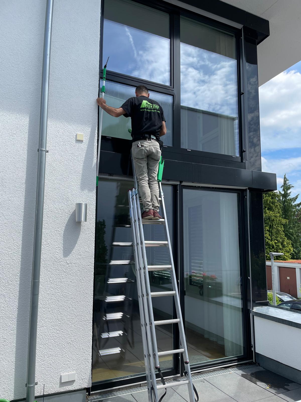 Aktiv Best Mitarbeiter bei der Fensterreinigung auf der Leiter